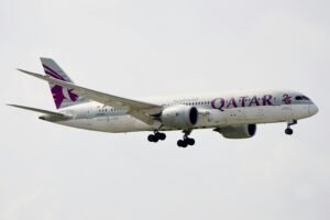 Qatar Airways Boeing 787-9 Dreamliner in mid-air, captured during daytime.