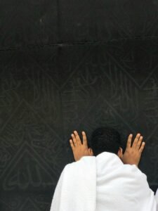 A pilgrim deep in prayer at the Kaaba in Makkah, symbolizing faith and devotion.